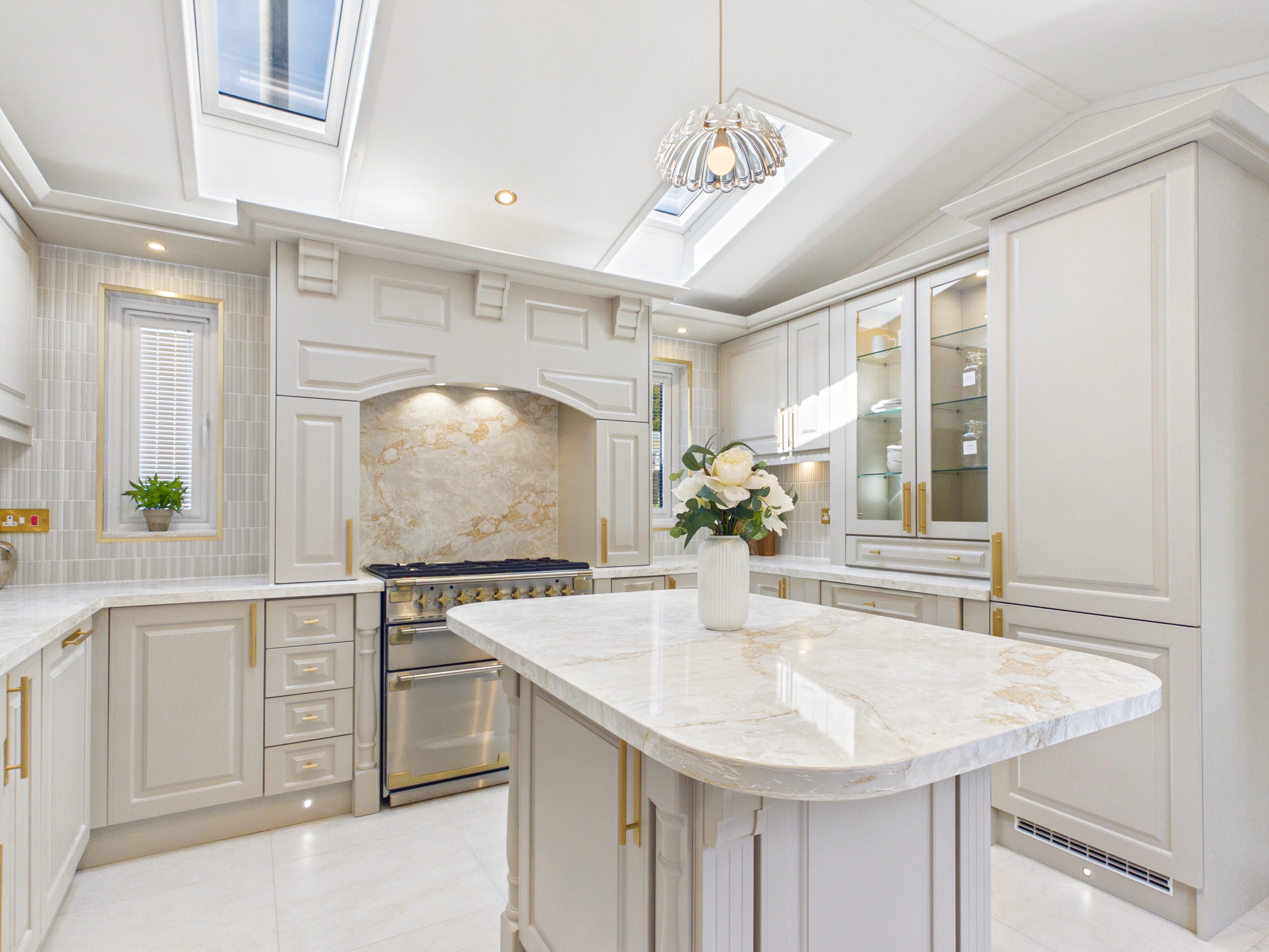 Diamond show home kitchen with roof windows, slender windows framing the cooker and a pendant light over the island