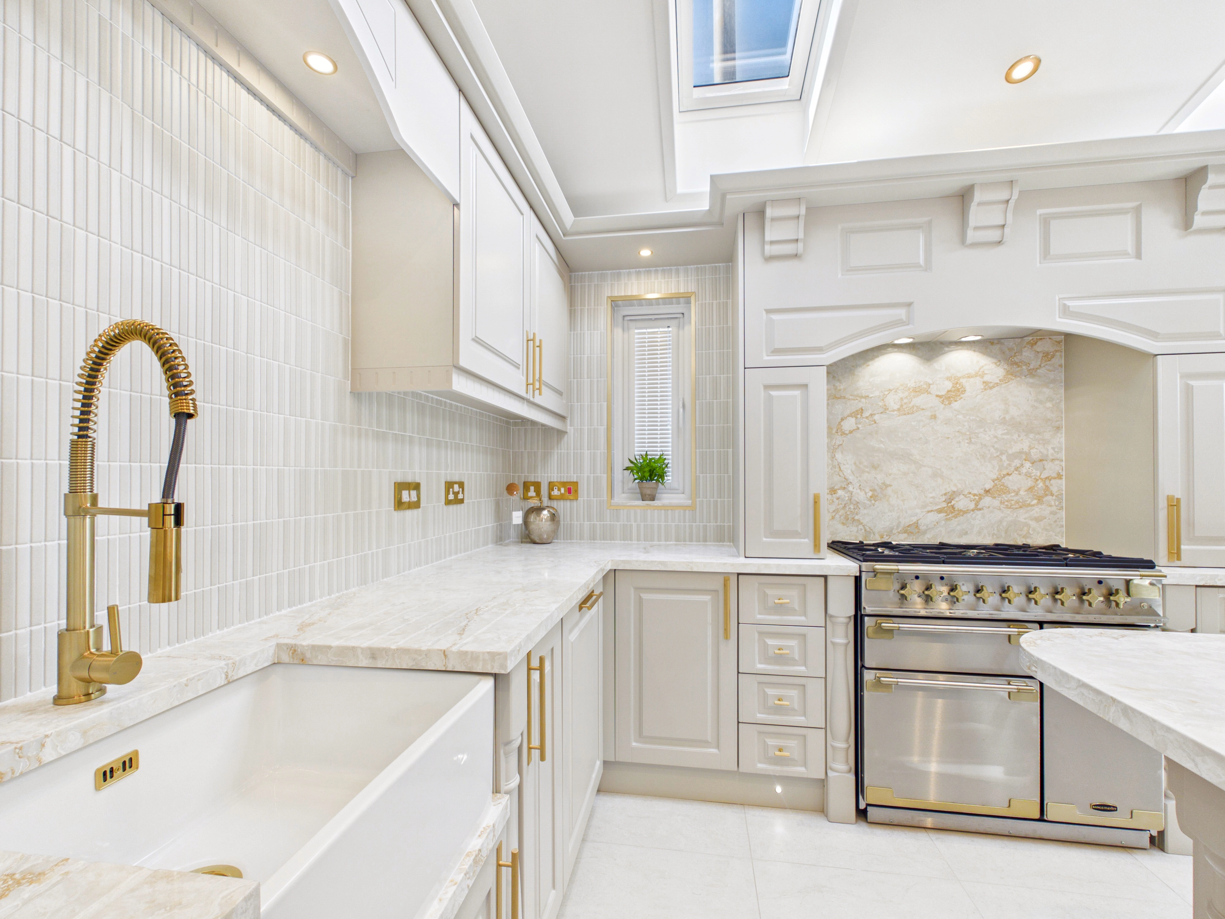 Diamond show home kitchen with a gold tap, quartz worktops and range cooker on the back wall