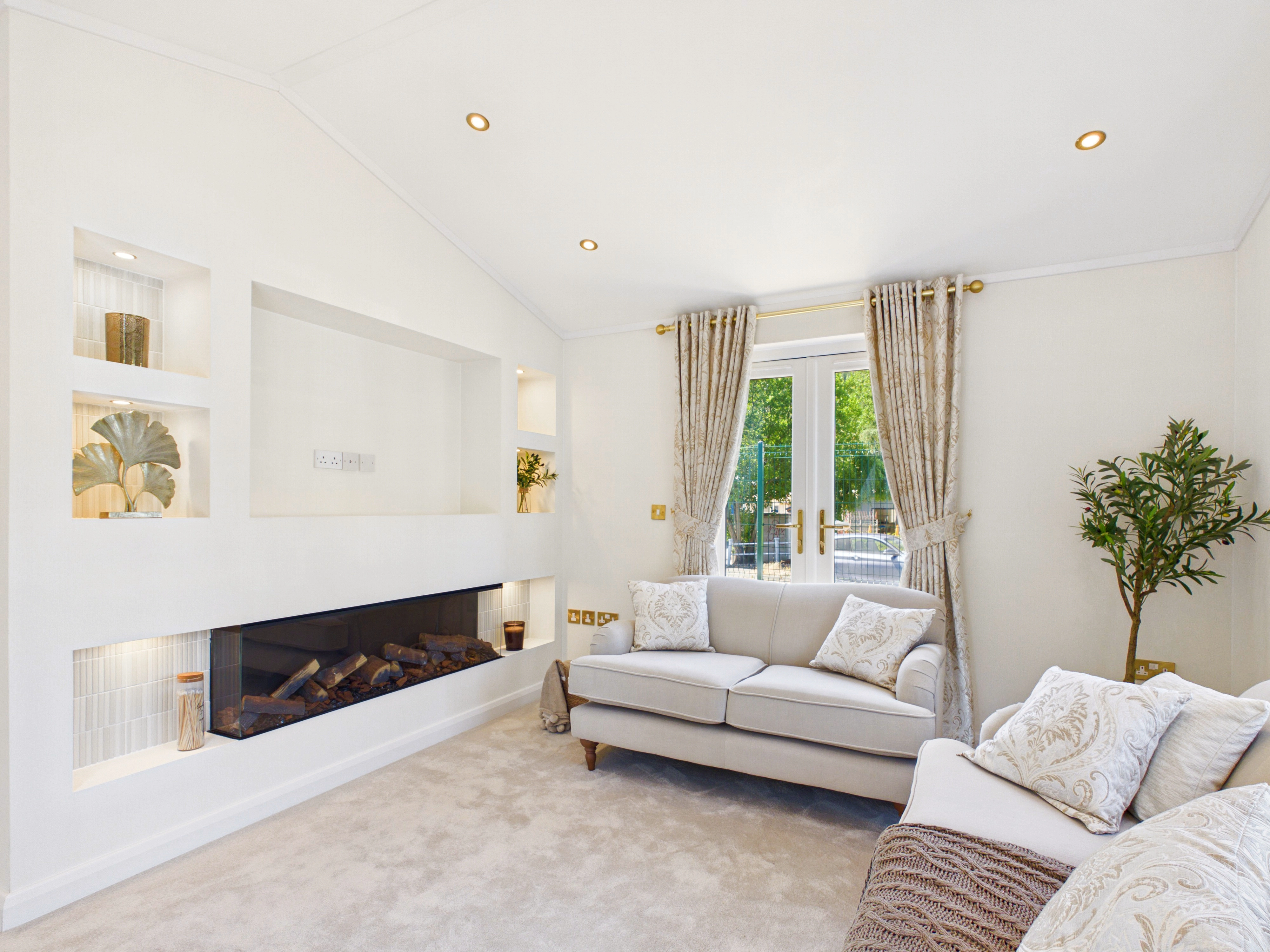 Diamond show home lounge with an illuminated media wall, display shelving and integrated widescreen fire