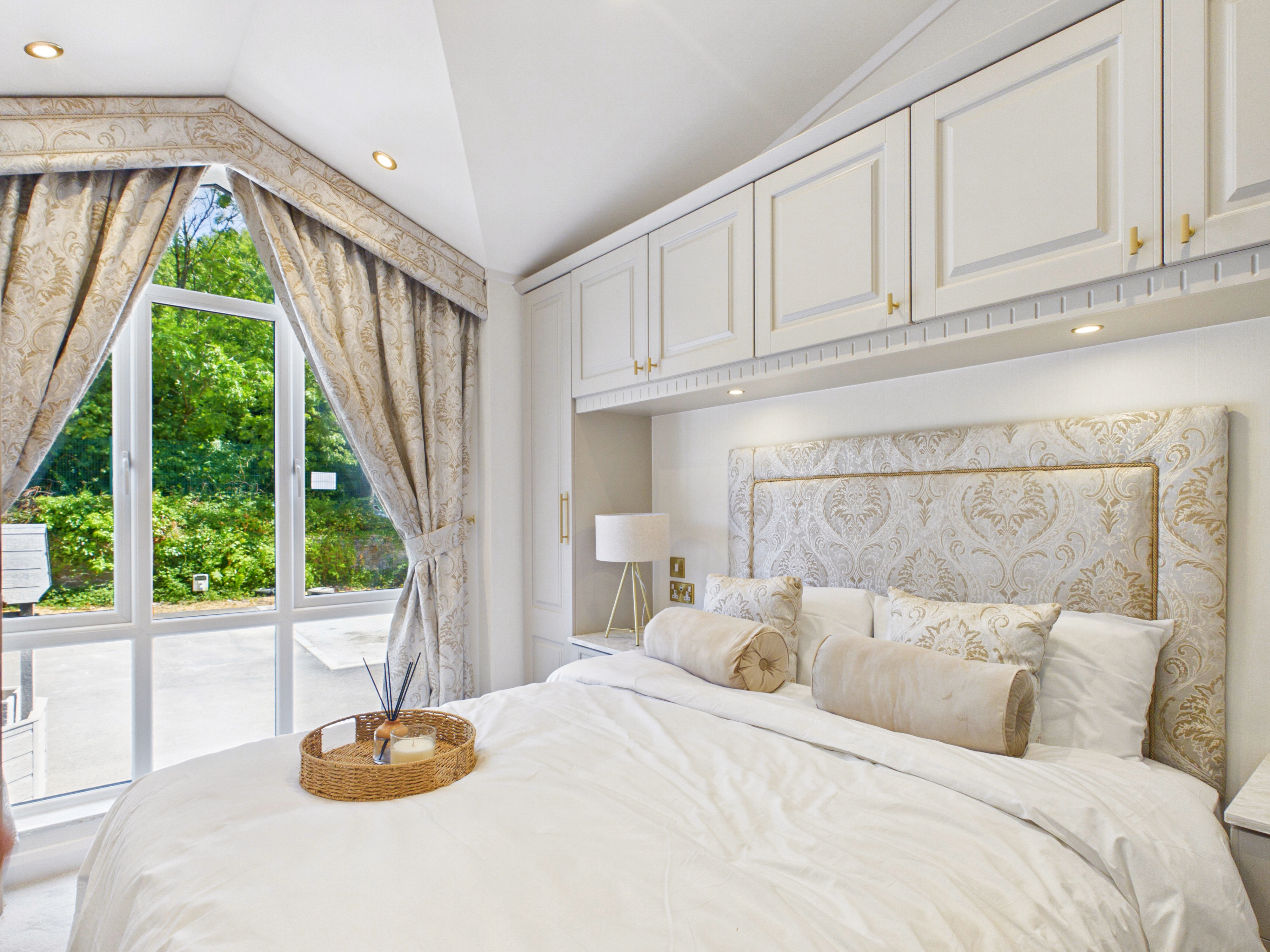 Diamond show home master bedroom with fitted wardrobes, integrated drawer storage and full-height windows