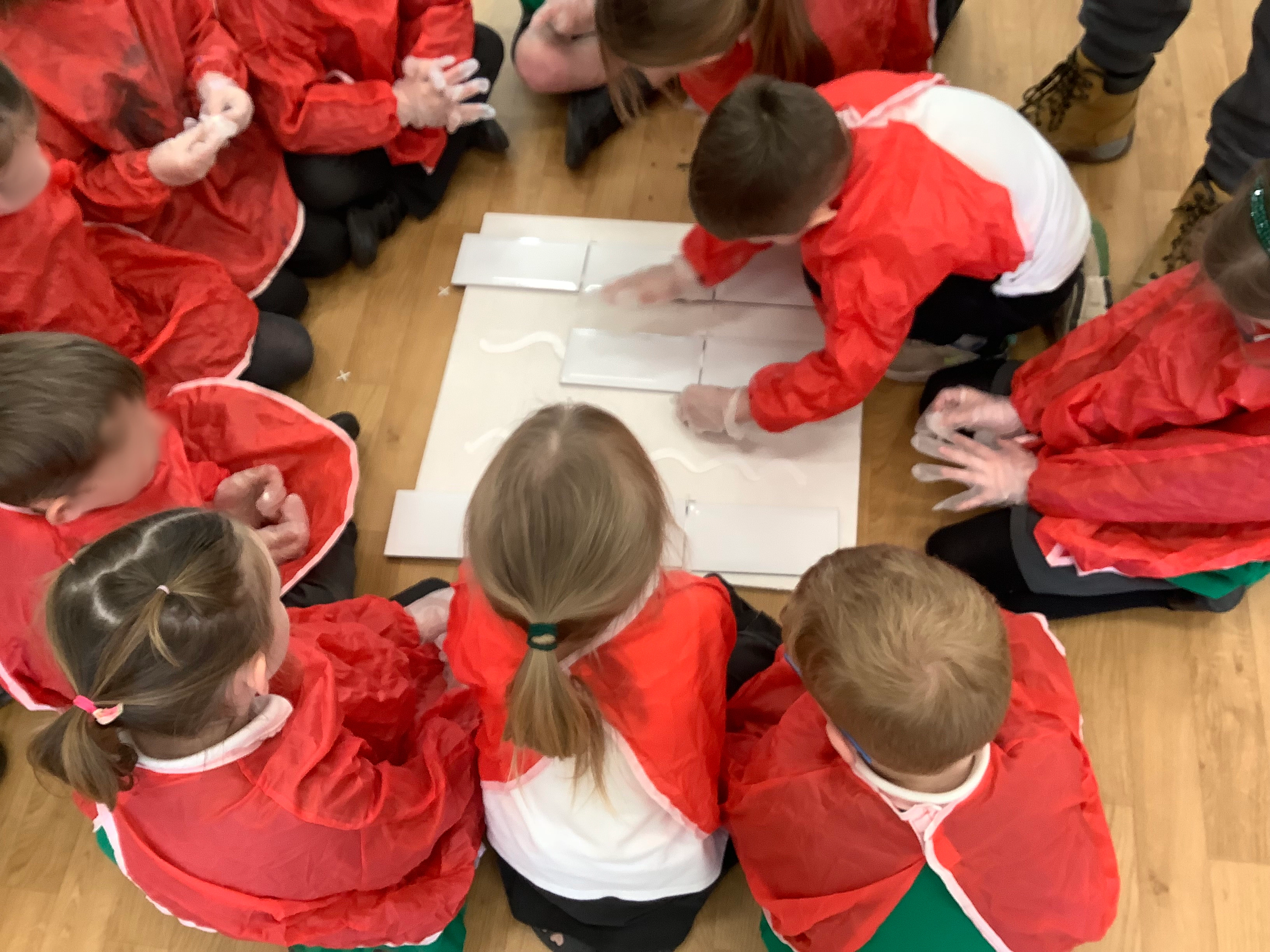 Disgyblion yn trefnu teils ceramig yn ystod yr ymweliad ysgol